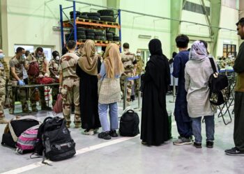 PIHAK tentera memeriksa bagasi yang dibawa oleh pelarian Afghanistan di Pangkalan Tentera Udara Perancis.-AFP