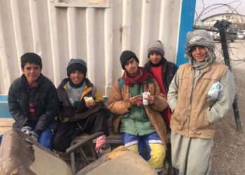 Kanak-kanak Afghanistan yang bekerja sebagai pengangkut barang berehat sekejap menikmati makanan yang diberikan sukarelawan Malaysia di Islam Qala, Afghanistan.
