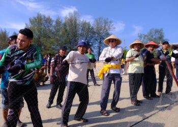 AHMAD Samsuri Mokhtar (tiga dari kiri)  tidak ketinggalan menarik pukat bersama nelayan pada Program Tarik Pukat Raya 2023 di Pantai Pulau Kekabu, Marang, Terengganu, hari ini. UTUSAN/PUQTRA HAIRRY ROSLI