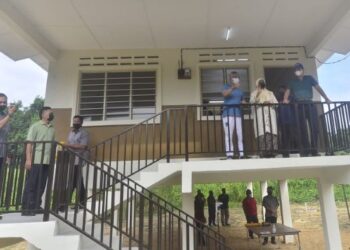 L-SULTAN ABDULLAH Ri’ayatuddin Al-Mustafa Billah Shah (berdiri atas, tiga dari kanan) berkenan mencemar duli menyempurnakan majlis penyerahan kunci kediaman di Kampung Acheh di Pekan, Pahang. - FOTO/SHAIKH AHMAD RAZIF