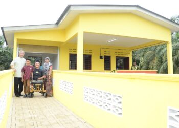 AL-SULTAN ABDULLAH Ri'ayatuddin Al-Mustafa Billah Shah (kiri) berkenan bergambar bersama Mohd. Khairi Othman dan isteri serta anaknya selepas Seri Paduka berkenan menyampaikan kunci rumah kurniaan Yayasan Al-Sultan Abdullah (YASA) di Kampung Tanjung Pulai di Pekan, Pahang. - FOTO/SHAIKH AHMAD RAZIF