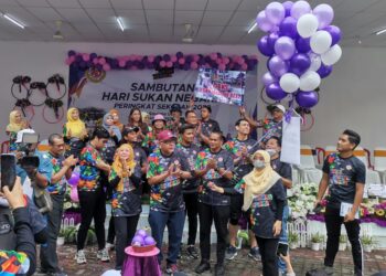Shaukei Kahar (tengah) bersama rakan-rakan pengulas sukan dan warga sekolah dalam majlis perasmian Hari Sukan Negara peringkat SK Saujana Utama semalam.