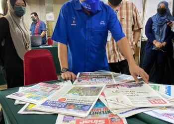 Ahmad Maslan melihat laporan akhbar mengenai Pilihan Raya Negeri (PRN) Melaka semasa melawat Pusat Media di Ayer Keroh, Melaka, semalam