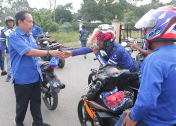 AHMAD MASLAN (kiri) bersalam dengan peserta Konvoi Bermotosikal Anak Muda BN di Kampung Lubok Sipar, Benut, Pontian, Johor.