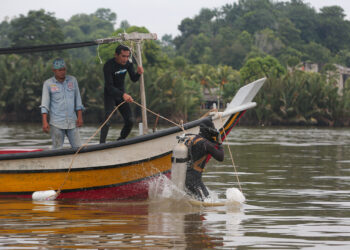 PENYELAM dari Syarikat Sumai Engineering membuat pemeriksaan kerosakan paip patah di dasar Sungai Terengganu dekat Pulau Sekati, kelmarin. -UTUSAN/PUQTRA HAIRRY