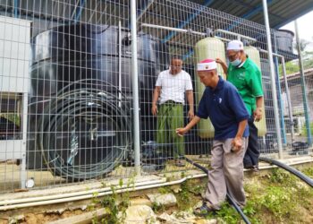 MOHD. Nasir Idris (kanan) meninjau sebuah telaga tiup yang dibina Jabatan Mineral dan Geosains untuk membantu penduduk mendapatkan bekalan air bersih di Kampung Batu 60, Tanjung Pari, Baling semalam. -UTUSAN/NORLIA RAMLI