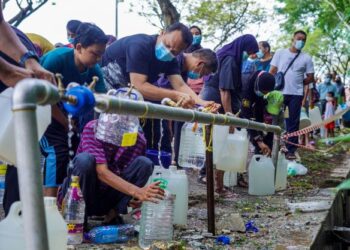PENDUDUK sekitar kawasan Keramat beratur untuk mendapatkan air bersih bagi kegunaan harian daripada pili awam yang disediakan Air Selangor berikutan gangguan bekalan air selepas empat Logi Rawatan Air (LRA) di Selangor terpaksa dihentikan operasi di Keramat AU3 di sini, semalam. -  UTUSAN/FARIZ RUSADIO
