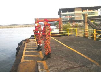 HUSSIN Ab. Rahman (kanan) meninjau air pasang besar di Jeti Pulau Ketam, Klang pagi tadi. - FOTO/ABDUL RAZAK IDRIS