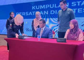 MUHAMAD AKMAL Saleh menyaksikan pertukaran dokumen MoU antara Johari Abu Kasim (kiri) dan Nordina Abdul Latif di sebuah hotel di Ayer Keroh, Melaka. - UTUSAN/AMRAN MULUP