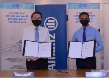 TONY Chieng (kiri) dan Joseph Gross menunjukkan dokumen kerjasama antara Allianz Life dan RHB Trustees Berhad di Kuala Lumpur, baru-baru ini.