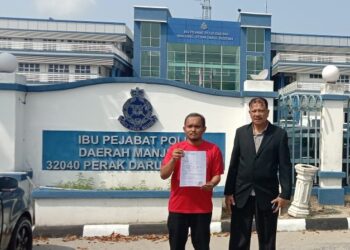 MOHD. Ikhmal Mohd. Iskandar (kiri) bersama Ahli Jawatankuasa Amanah Kawasan Lumut, Abdul Mutalib Zakaria memegang salinan laporan polis terhadap Abdul Hadi Awang di IPD Manjung di Lumut hari ini. - UTUSAN/SHAMSUL KAMAL AMARUDIN