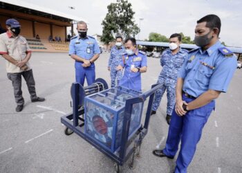 NORHAFIFI ISMAIL (tengah) dan Pengarah APM Negeri Sembilan, Mohd. Syukri Madnor (kanan) melihat sistem amaran awam semasa ujian siren di Pejabat APM Negeri Sembilan di Seremban hari ini. - UTUSAN/MOHD. SHAHJEHAN MAAMIN