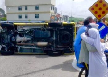 Ambulans membawa pesakit terbalik selepas terbabit kemalangan dengan kereta di persimpangan lampu isyarat Kampung Pisang, Batu Gajah hari ini. - MEDIA SOSIAL