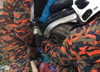 ANGGOTA bomba membantu jururawat yang tersepit setelah ambulans dinaikinya terbabas di Kilometer 285, Lebuh Raya Utara-Selatan arah utara dekat Ipoh hari ini. - FOTO/IHSAN JBPM PERAK