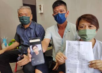 YAP Ban Kim (tengah) dan Wong Chwee Foon  menunjukkan gambar anak serta laporan polis berhubung kehilangan anak mereka ketika dikunjungi Koh Kim Swee di Taman Indah, Tampin, hari ini.-UTUSAN/NOR AINNA HAMZAH