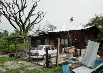KEADAAN rumah yang rosak dan pokok tumbang yang menghalang lalu lintas akibat ribut di kawasan Tasek, Ipoh hari ini. - FOTO/ZULFACHRI ZULKIFLI