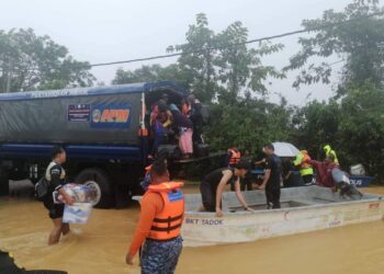 ANGGOTA polis membantu mangsa banjir berpindah di Besut, Terengganu, hari ini.