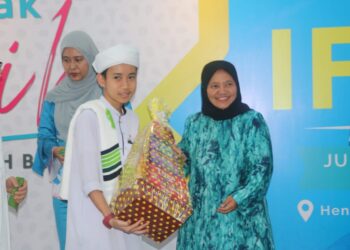 RADZIMAH Mohd. Radzi  (kanan) menyampaikan bakul makanan dan duit raya kepada seorang pelajar tahfiz pada Majlis Iftar Semarak Kasih bersama ANIH Berhad di Hentian Sebelah Bentong di Bentong, Pahang. - UTUSAN/SALEHUDIN MAT RASAD