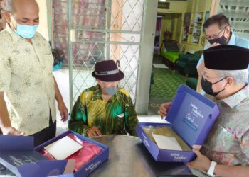 ANNUAR Musa (kanan) menyampaikan sepersalinan baju Melayu ketika menziarah Seniman Mat Sentol di kediamannya di Jalan Rajawali, Larkin, Johor Bahru hari ini. -UTUSAN/KHAIRUL MOHD ALI