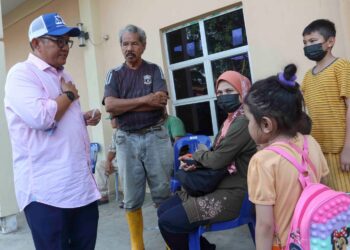 ANUAR Basiran (kiri) berbual dengan mangsa banjir ketika meluangkan masa melawat mangsa banjir di PPS di Dewan Komuniti Dengkil, Selangor. - UTUSAN/FAISOL MUSTAFA
