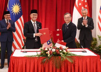 ANWAR Ibrahim dan Lee Hsien Loong (belakang) menyaksikan pemeteraian MoU antara Kementerian Perdagangan Antarabangsa dan Industri Malaysia dan Singapura, hari ini. - FB ANWAR IBRAHIM