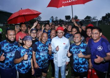 ANWAR Ibrahim bersama pemain pasukan yang menyertai perlawanan bola sepak persahabatan di Meru Permai di Ipoh, Perak. - UTUSAN/MUHAMAD NAZREEN SYAH MUSTHAFA