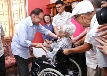 ANWAR Ibrahim (kiri) menziarahi Ahmad Fawzi Shafii di Desa Seri Ampang, Ipoh hari ini. - UTUSAN/MUHAMAD NAZREEN SYAH MUSTHAFA