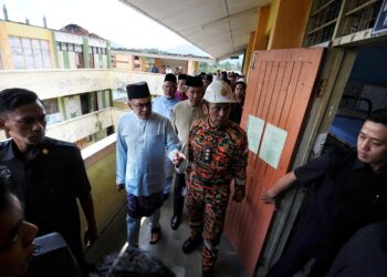 ANWAR Ibrahim melihat keadaan bangunan asrama pelajar Sekolah Menengah Kebangsaan Agama (SMKA) Dato' Haji Abu Hassan Haji Sail di Pedas, Rembau, semalam yang musnah dalam kebakaran pada Julai tahun lalu. - UTUSAN/MOHD. SHAHJEHAN MAAMIN.