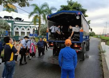 ANGKATAN Pertahanan Awam Malaysia (APM) Pahang membantu menghantar 16 calon SPM, empat guru dan seorang pegawai ke SMK Chong Hwa di Kuantan, Pahang selepas laluan ke sekolah berkenaan ditutup untuk kenderaan kecil berikutan banjir, pada pukul 7.15 pagi. - FOTO IHSAN APM PAHANG