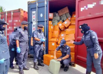 ABDULLAH Jaapar (tengah) menunjukkan antara minuman keras yang dirampas pada kontena di Wisma Kastam, Pulau Indah, Pelabuhan Klang hari ini.