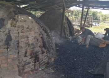 ZULKFLE Ismail menyusun arang di hadapan gok di Kampung Gong Beris, Marang, Terengganu, baru-baru ini. - UTUSAN/NOOR HAYATI MAMAT