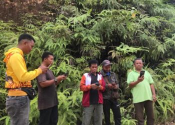 BEBERAPA penduduk Orang Asli mencari talian internet di kawasan berbukit di Pos Balar, Gua Musang, Kelantan. - UTUSAN/AIMUNI TUAN LAH