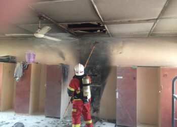 ANGGOTA bomba memeriksa dan memadamkan api yang merebak ke bahagian siling dalam kebakaran asrama di Sekolah Menengah Kebangsaan (SMK) Felda Jengka 2 di Maran, Pahang. - FOTO/IHSAN JBPM PAHANG