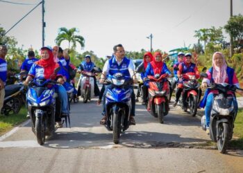 ASYRAF Wajdi Dusuki (tengah) bermotosikal bersama jentera BN ketika kempen PRU15 di Gerik, Perak. - GAMBAR MEDIA SOSIAL