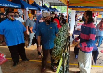 IZHAM Hashim (tengah) meninjau gerai jualan Program Jualan Prihatin Rakyat di Taman Berjaya, Sabak Bernam, semalam.