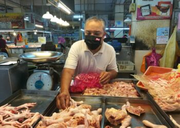 PENIAGA, Shahran Osman mengasingkan bahagian ayam yang dijualnya di Pasar Awam Larkin, Johor Bahru, Johor. - MINGGUAN/ MOHAMAD FAIZAL HASHIM