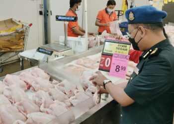 MUHAMAD Radzi Johan membuat pemeriksaan dan pemantauan harga siling runcit ayam standard yang ditetapkan pada harga RM9.40 sekilogram di sebuah pasar raya di Kuantan, Pahang. - UTUSAN/ DIANA SURYA ABD WAHAB