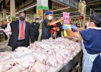 S. Veerapan (kiri) bersama Ketua Pegawai Penguat Kuasa KPDNHEP Negeri,  Abd. Muis Samsudin ketika membuat pemantauan bekalan ayam di sebuah pasar raya besar di negeri ini. - UTUSAN/MOHD. SHAHJEHAN MAAMIN