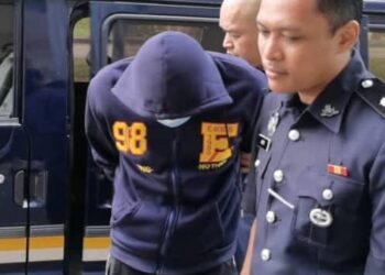 CHEK Norhafizzi Chek Nor (tengah) diiringi polis untuk menghadiri perbicaraan di Mahkamah Pasir Mas, Kelantan, hari ini. - UTUSAN/ROSALWANI CHE SOH