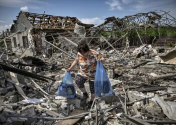 SEORANG wanita mengambil barangan yang masih boleh digunakan di celah runtuhan selepas rumahnya terkena serangan udara di Sloviansk di Donbas. - AFP