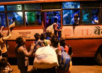ORANG ramai bersesak menaiki bas untuk pulang ke kampung bagi mengelak terkandas akibat perintah berkurung. - AFP