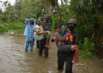 PASUKAN keselamatan mendukung kanak-kanak dan warga emas selepas Taufan Yass membadai Bengal Barat, India. - AFP