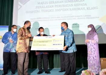 ALEXANDER Nanta Linggi menyaksikan Hasnol Zam Zam Ahmad (kiri) menyerahkan mok cek bernilai RM100,000 kepada Dr. Zulkarnain Mohd. Rawi dalam majlis penyerahan sumbangan dan peralatan perubatan di HTAR, Klang, Selangor, hari ini. - UTUSAN / ZULFADHLI ZAKI