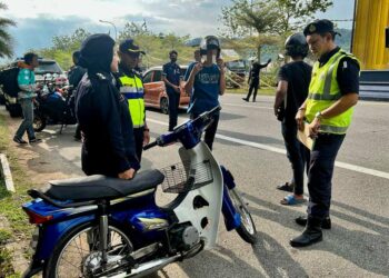 FATIMAH Mohamed Ali Piah (kiri) memeriksa salah sebuah motosikal ‘hantu’ yang ditahan sewaktu Ops HRA 2023 di KM26 Jalan Changlun-Kuala Perlis, Perlis hari ini. -UTUSAN/ASYRAF MUHAMMAD