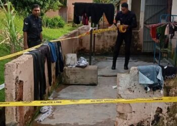 SEPASUKAN polis memeriksa sebuah rumah di Ladang St Helier, Bahau, Jempol, lokasi suami menetak isteri kelmarin.- IHSAN/POLIS