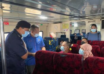 WARI KIEW (kiri) bersama Pengarah Angkatan Pertahanan Awam (APM) negeri, Mohd Izaimi Md Daud (dua dari kiri) memeriksa dokumen penumpang yang ingin ke Pulau Langkawi dari Terminal Feri Kuala Perlis, Perlis hari ini.- UTUSAN/NAZLINA NADZARI