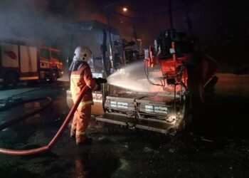 ANGGOTA bomba memadam kebakaran jentera berat di Sungai Malau di Larut hari ini. - UTUSAN/IHSAN JBPM