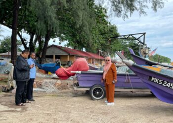 TUMINAH Kadi (kanan) diberi penerangan berkenaan isu monsun timur laut dihadapi 300 nelayan di Tanjung Kling, Melaka. - UTUSAN/DIYANATUL ATIQAH ZAKARYA
