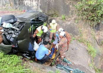 ANGGOTA bomba mengeluarkan mangsa yang tersepit dalam kemalangan di Kilometer 265.6 Lebuh Raya Utara-Selatan arah selatan, Ipoh hari ini. - UTUSAN/JBPM PERAK
