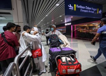 ISMAlL Sharaai, 61, bersama isterinya, Rohani Md Yasin, 50, disambut anak-anak mereka di KLIA, Sepang, Selangor, hari ini. - UTUSAN/FAISOL MUSTAFA